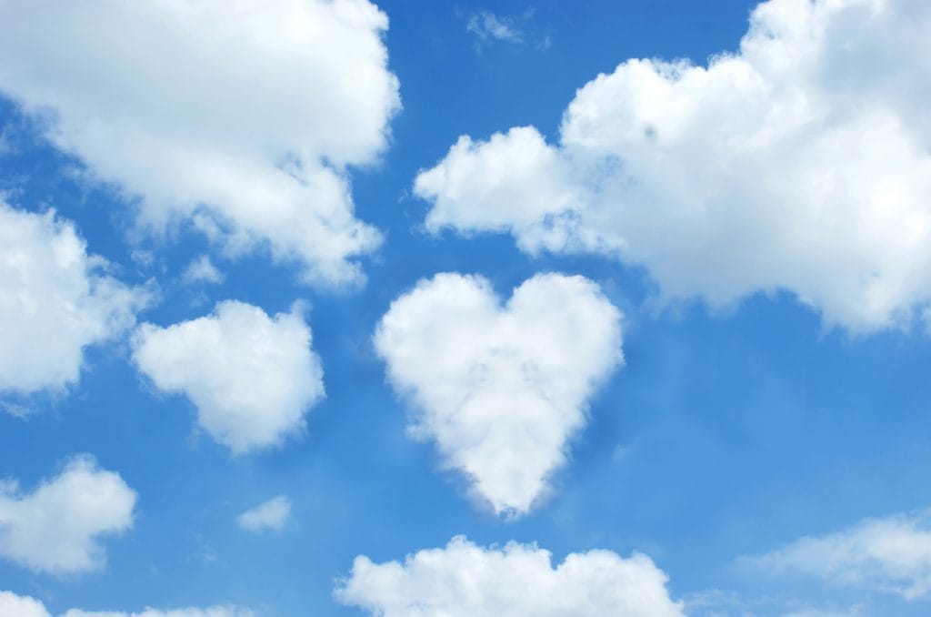 Sunny blue sky with a cloud in the shape of a heart